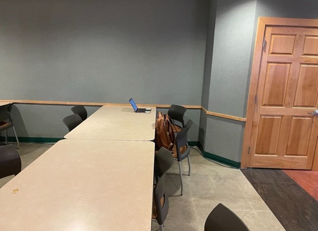 A room with a computer on a table Description automatically generated