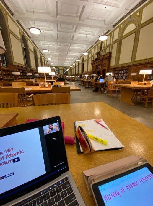 A computer on a table in a library Description automatically generated