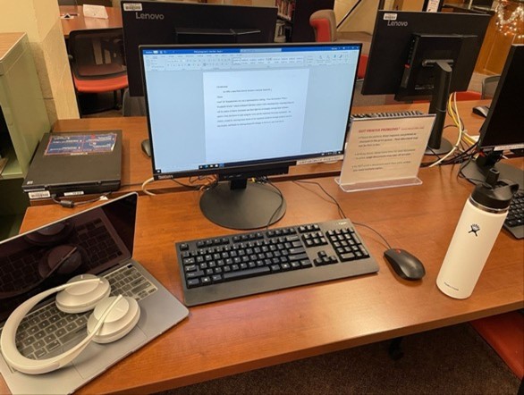 A desk with a computer and a computer Description automatically generated